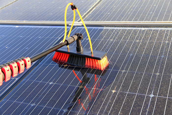 black solar panel cleaning brush on solar panel before and after cleaning